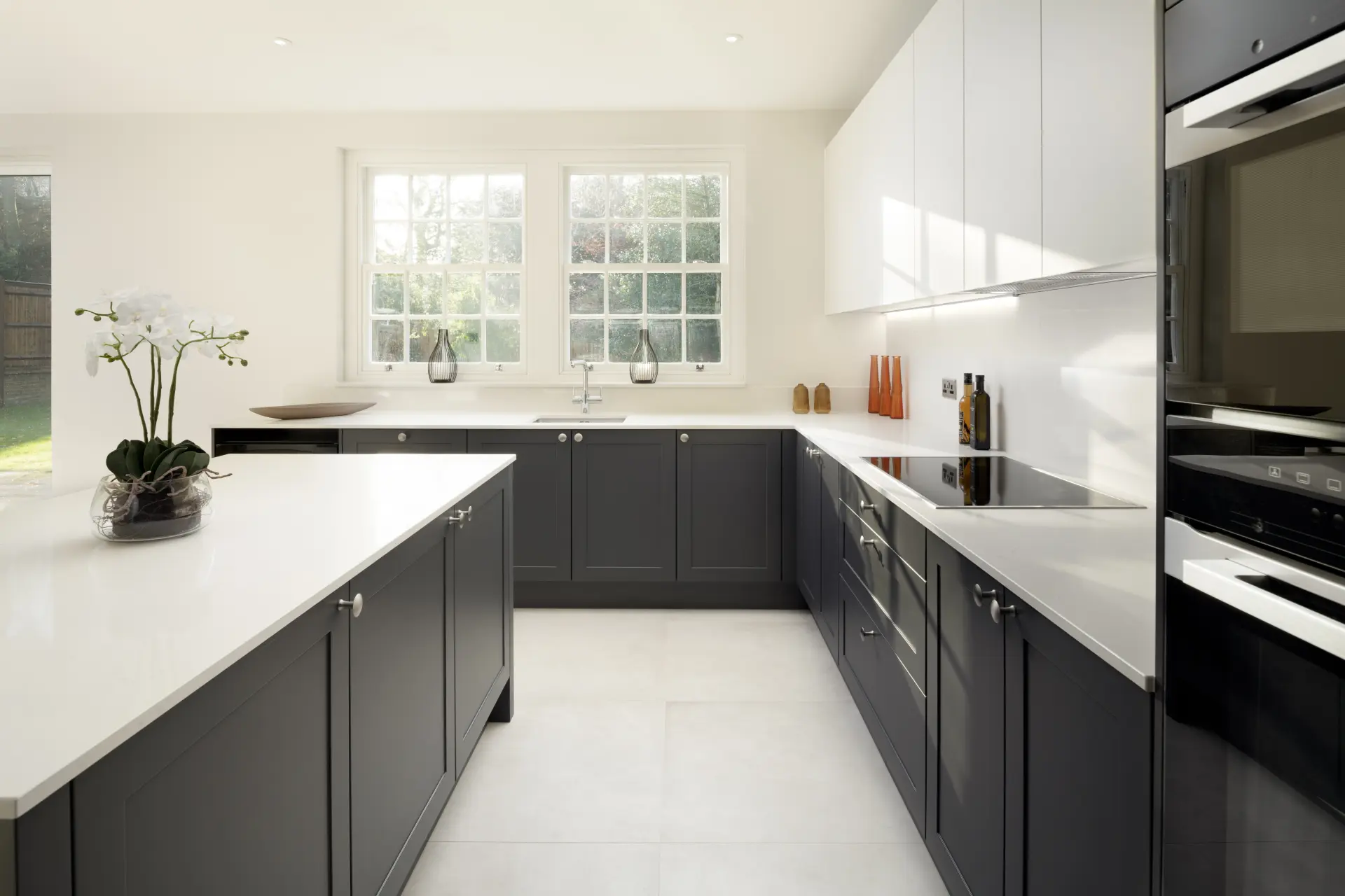 a kitchen with white cabinets and black counter tops