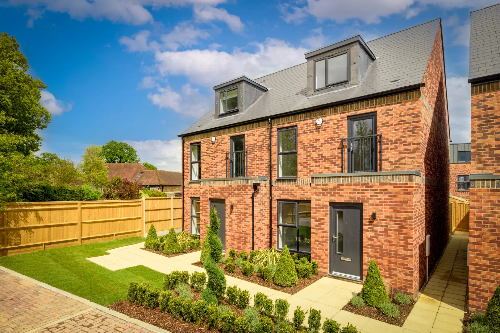 a brick house with a yard and a fence