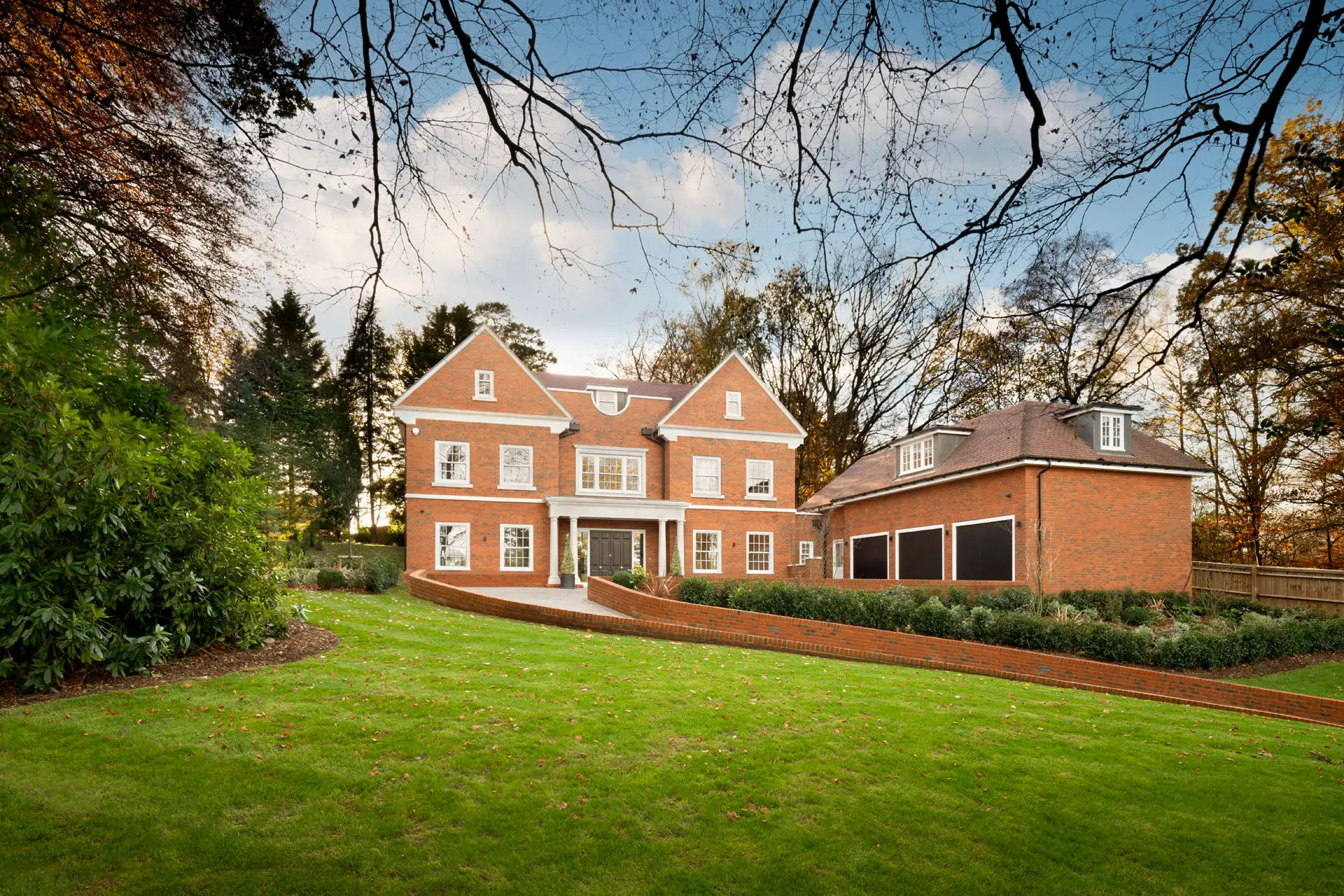 a large brick house with a lawn and trees
